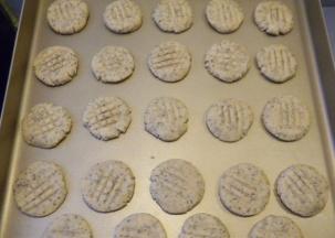用手将小球压扁，放入烤盘里，再用叉子压上花纹，烤箱预热，上火180度、下火150度烤25分钟即可。