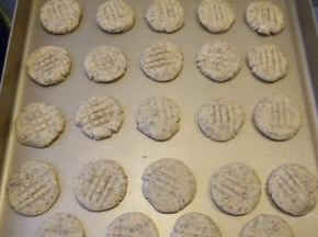 用手将小球压扁，放入烤盘里，再用叉子压上花纹，烤箱预热，上火180度、下火150度烤25分钟即可。