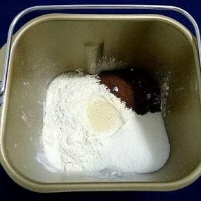 把面包用料除黄油以外的材料都放进面包机，先放液体，在放面粉，酵母放中心，盐、糖、可可粉放在三个角