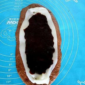 把麻薯放在面团上，取一份豆沙铺在上面