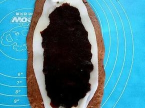 把麻薯放在面团上，取一份豆沙铺在上面