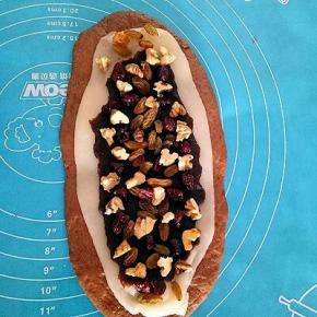 把蔓越莓、葡萄干、核桃铺在上面