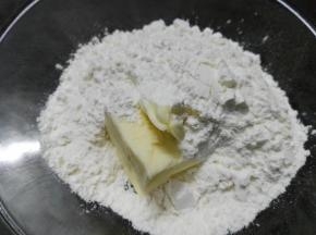 在软化的黄油中撒入过筛的低粉混合均匀
