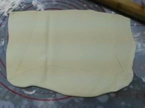 操作台上撒少许高粉防粘，将松弛好的水油皮擀成油酥宽度两倍的长方形，油酥放在1/2处，水油皮面片对折封口捏紧