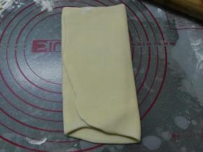 将其稍微擀长，自两端分别向1/3处内折，将面团再次擀长，两端同样分别向1/3处内折，将其再次擀成40*22的长方形面片