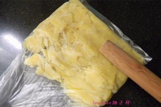 蒸熟的土豆晾凉后，放入保鲜袋里用擀面杖压碎；