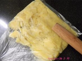 蒸熟的土豆晾凉后，放入保鲜袋里用擀面杖压碎；