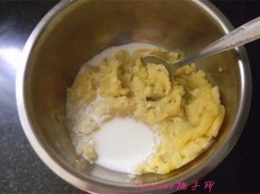 压碎的土豆泥放入料理盆里，一点点加入牛奶，调成稀稠合适的土豆泥；