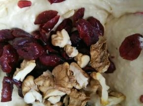 倒入蔓越莓干和核桃仁，如果蔓越莓干和核桃仁太大可以提前切成小块儿