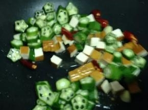 倒入秋葵和香干，调入白醋。大火炒均匀。