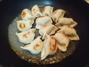 倒入半碗水，水量没过饺子一半即可。盖上盖子小火煎至。约3分钟，期间摇动平底锅，避免粘锅。水份蒸发完，饺子也就熟了。