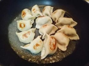 倒入半碗水，水量没过饺子一半即可。盖上盖子小火煎至。约3分钟，期间摇动平底锅，避免粘锅。水份蒸发完，饺子也就熟了。