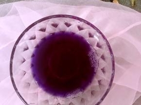 4.将一勺蜂蜜放入晾凉的蝶豆花液体中，搅拌均匀，这时液体变成紫色