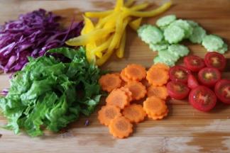 把蔬菜切丝，圣女果，对半切开。黄瓜胡萝卜，我切成片了，用工具刻了个花边。