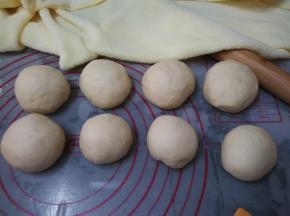 和面结束后再发酵50分钟(我是用面包机的酸奶功能进行发酵的)，取出排气，面团分8个，团圆，盖湿布松弛10分钟