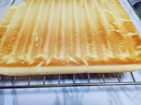 蛋糕烤好后，戴上隔热手套迅速取出烤盘，垂直摔一下，震出热气，趁热撕下油纸，翻面朝上，撕掉油纸后马上将蛋糕翻面，正面朝上，不然水蒸气加热气会导致蛋糕皮被粘掉。