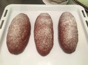 取出面包胚，烤箱预热180度，均匀地在面包胚上筛些干粉