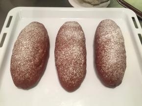 取出面包胚，烤箱预热180度，均匀地在面包胚上筛些干粉