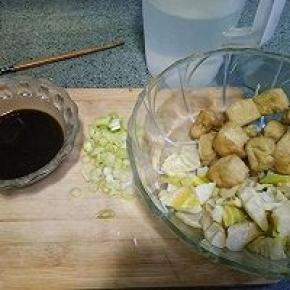 笋切滚刀块，和油豆腐一起放入碗中备用。葱切圈。酱油，盐，白糖，醋，淀粉放入碗中加入半碗水调汁备用