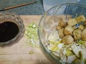 笋切滚刀块，和油豆腐一起放入碗中备用。葱切圈。酱油，盐，白糖，醋，淀粉放入碗中加入半碗水调汁备用