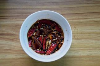 把姜片、蒜片、八角、桂皮、茴香和干辣椒放碗里，加酱油、白糖、料酒和黑胡椒粉调好汁