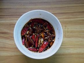 把姜片、蒜片、八角、桂皮、茴香和干辣椒放碗里，加酱油、白糖、料酒和黑胡椒粉调好汁