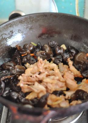 翻炒片刻后，加入五花肉，加盐、生抽调味。