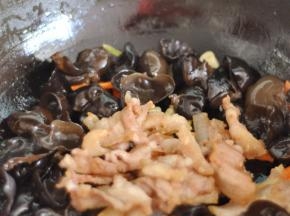 翻炒片刻后，加入五花肉，加盐、生抽调味。