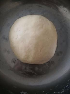 和面盆中倒入牛奶，白糖和酵母，酵母融化后倒入面粉揉成光滑的面团。