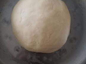 和面盆中倒入牛奶，白糖和酵母，酵母融化后倒入面粉揉成光滑的面团。