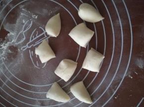 将刚刚预留的四分之一面团也分成差不多的八小份，搓成一边尖一边圆柱的形状