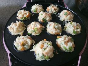 章鱼小丸子机刷点食用油，用筷子把每个洞洞都填满，盖上盖子，大概二十来分钟就熟了，可以时不时打开看一下。