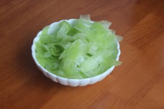 用刮皮刀将莴笋一片片的刮下来，撒上盐，用手抓均匀，腌制10分钟。