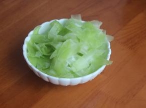 用刮皮刀将莴笋一片片的刮下来，撒上盐，用手抓均匀，腌制10分钟。