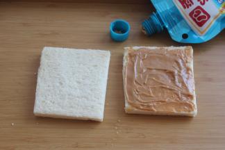 吐司面包上挤上花生酱，涂抹均匀。