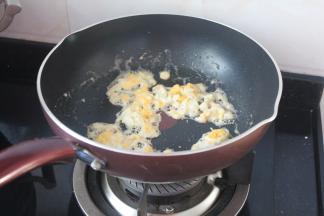 做锅烧热后放油炒熟鸡蛋，用铲子弄碎趁热加点盐装出待用。