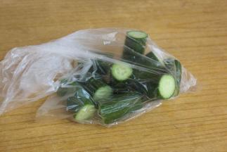 把黄瓜切成段，放入保鲜袋里面。用刀使劲的拍