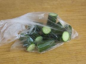 把黄瓜切成段，放入保鲜袋里面。用刀使劲的拍