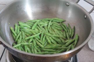 坐锅烧热后放比平时多两倍的油。放入四季豆小油炸至金黄色。
