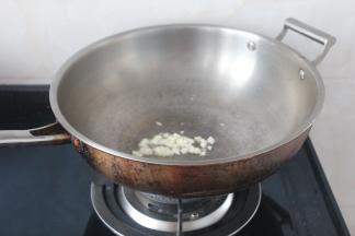 另起锅烧热后放油爆香大蒜出香味。