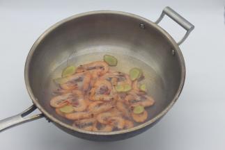 坐锅烧水至开放姜片，然后加入处理好的基围虾。