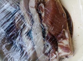 将猪肉连同腌制料一起倒入一个厚、结实不易破的塑料食品袋中，排出空气，密封起来