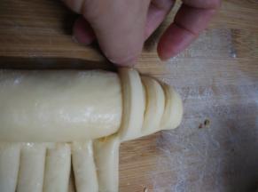 将小面条卷到长面团上，卷的时候要稍微将小面条拉的长一点，让小面条卷过去并压在长面团的底部，这样发酵以后才会好看