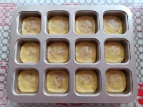 凤梨酥胚放入学厨的12连方杯模具中，用手压平边角，我用布丁瓶压了一圈痕迹