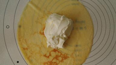 再在芒果上覆盖一大勺奶油，上下左右叠好，收口朝下