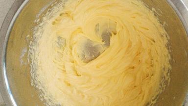 鸡蛋液分两次加入黄油里，开动打蛋器打发至黄油蓬松颜色变浅