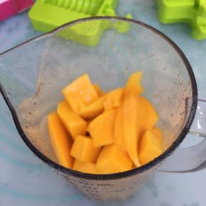 将切好的芒果倒入搅拌杯里。