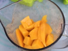 将切好的芒果倒入搅拌杯里。