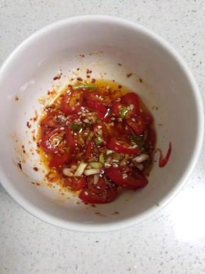 装在碗里，放入辣椒粉，白芝麻、盐、白糖。锅里放入适量的食用油烧至七成热，然后淋入调料碗中，搅拌均匀。（倒入一些酱油和醋、芝麻油）