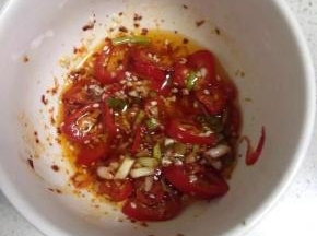 装在碗里，放入辣椒粉，白芝麻、盐、白糖。锅里放入适量的食用油烧至七成热，然后淋入调料碗中，搅拌均匀。（倒入一些酱油和醋、芝麻油）